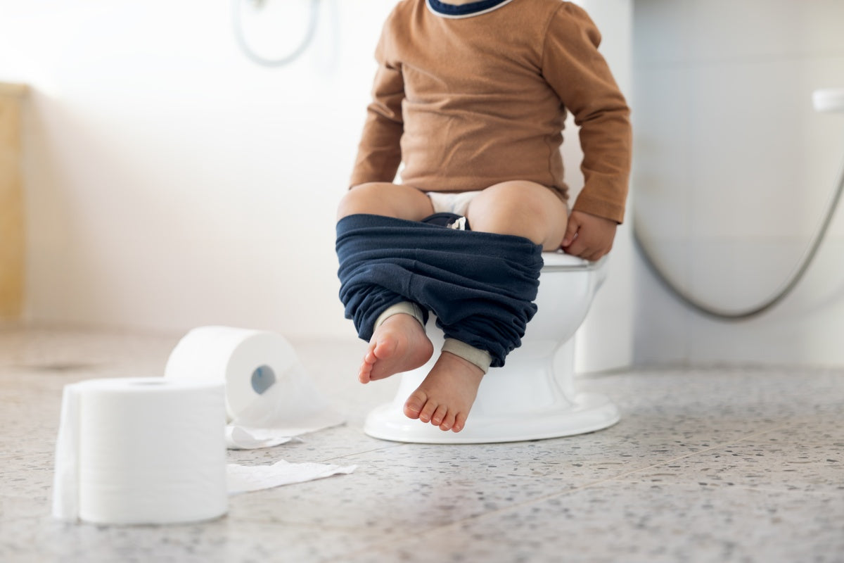 Toddler sitting on toilet experiencing antibiotic-associated diarrhea