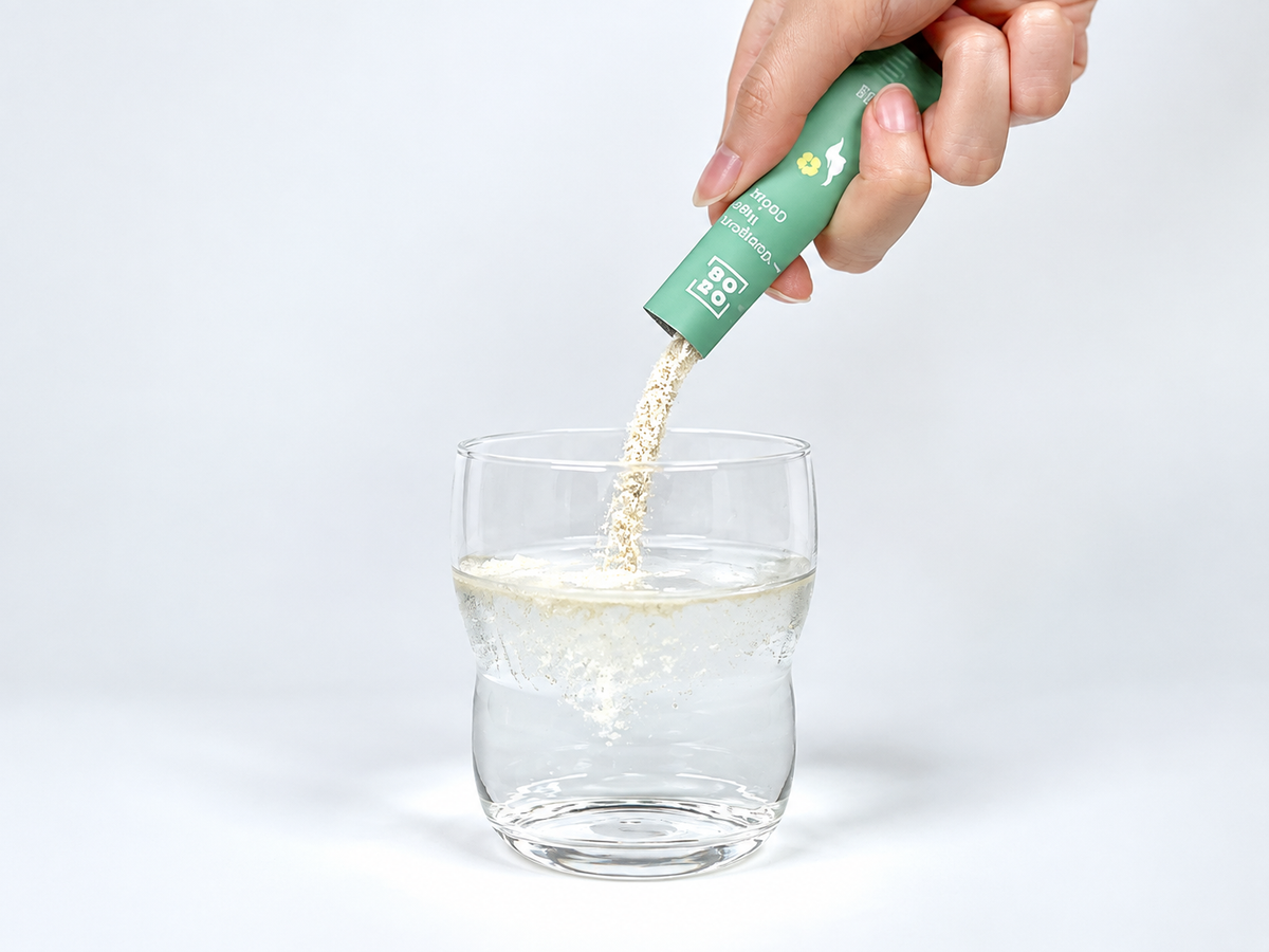 Pure Collagen Powder from Younglong, a 100% plant-based powder made from golden hibiscus, being poured into a glass of water.