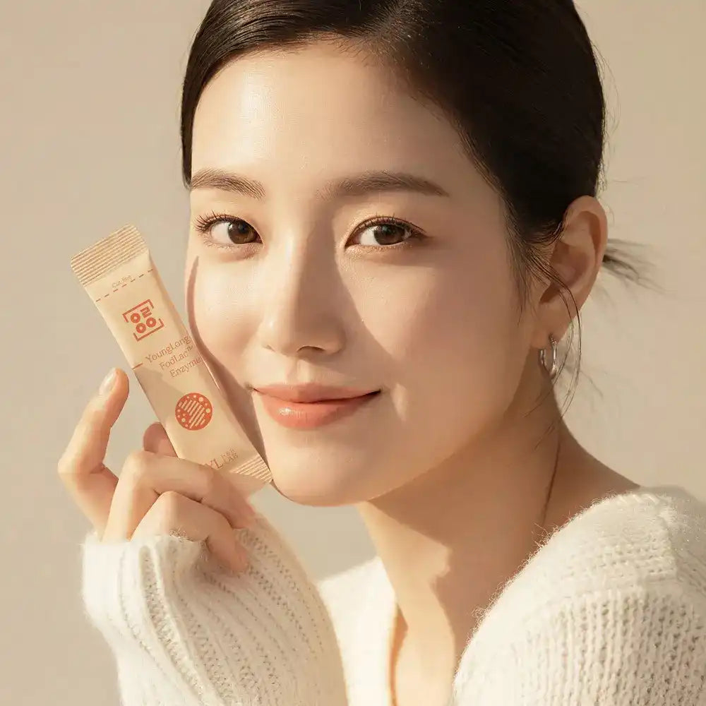 Smiling woman holding enzyme supplement stick pack, natural lighting, wellness concept