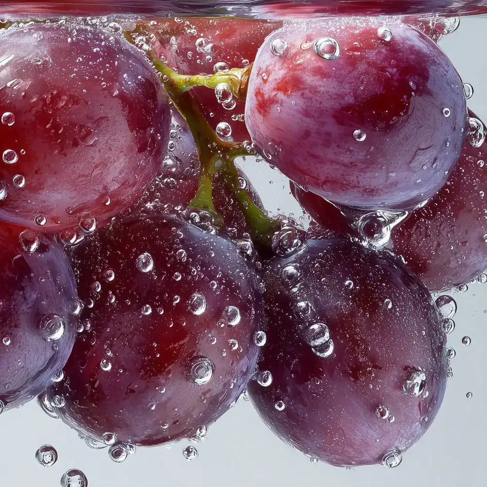 Fresh red grapes submerged in water with bubbles, close-up for antioxidant supplements