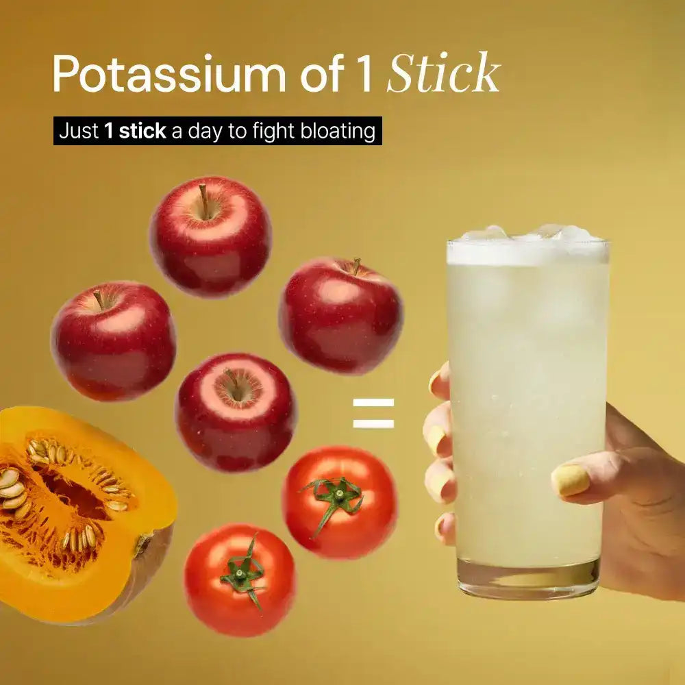 Hand holding a glass of supplement drink, equal in potassium to apples, tomatoes, and pumpkin, on yellow background