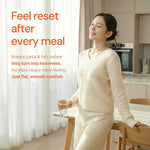 Smiling woman in cozy home kitchen holding glass of water, comfort and wellness message on side